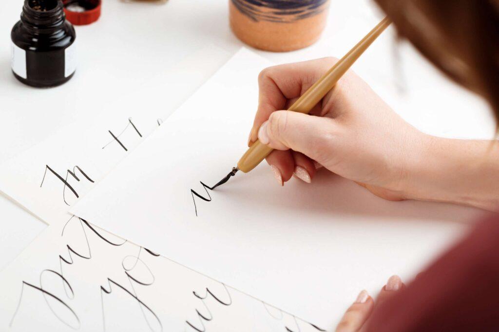 Dlaczego kaligrafia jest potrzebna dla dzieci w dobie różnych technologii? kaligrafia,kaligrafia alfabet,kaligrafia litery,kaligrafia ćwiczenia,kaligrafia dla dzieci Girl-writing-calligraphy-postcards-art-design-scaled