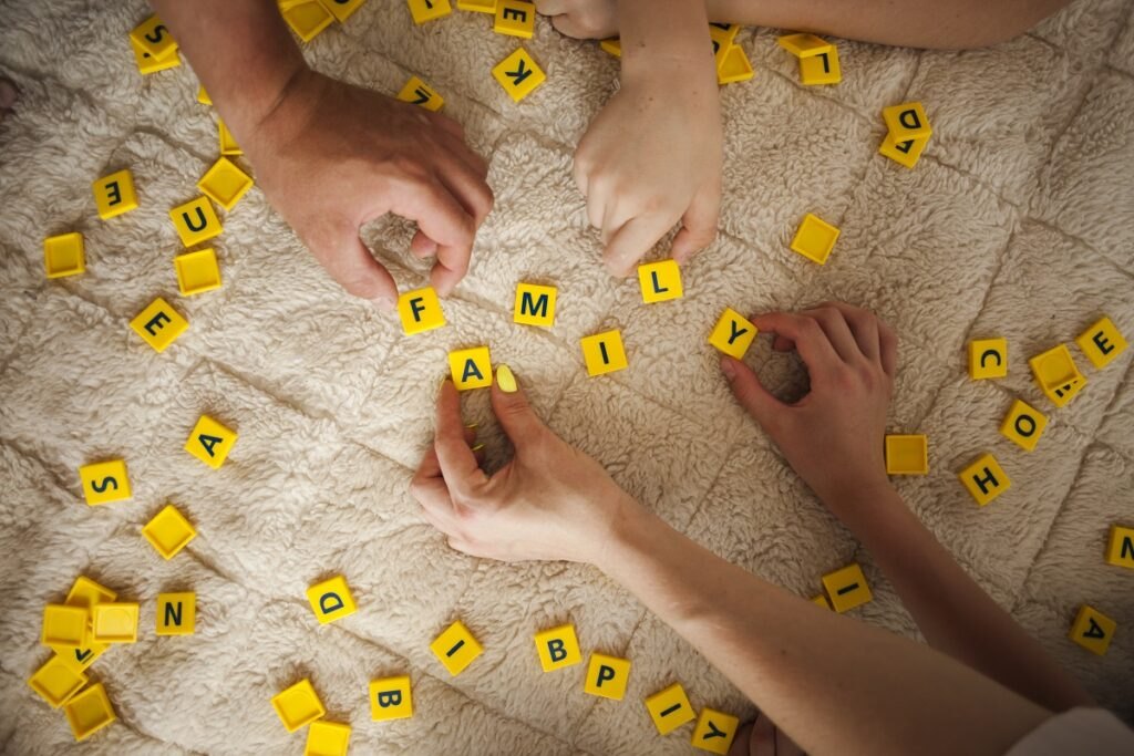 Korzyści z anagramu dla dzieci Hands-playing-scrabble-game-carpet-home
