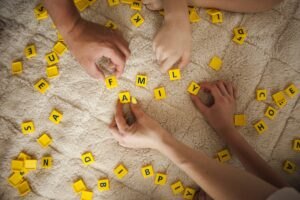 Korzyści z anagramu dla dzieci Hands-playing-scrabble-game-carpet-home