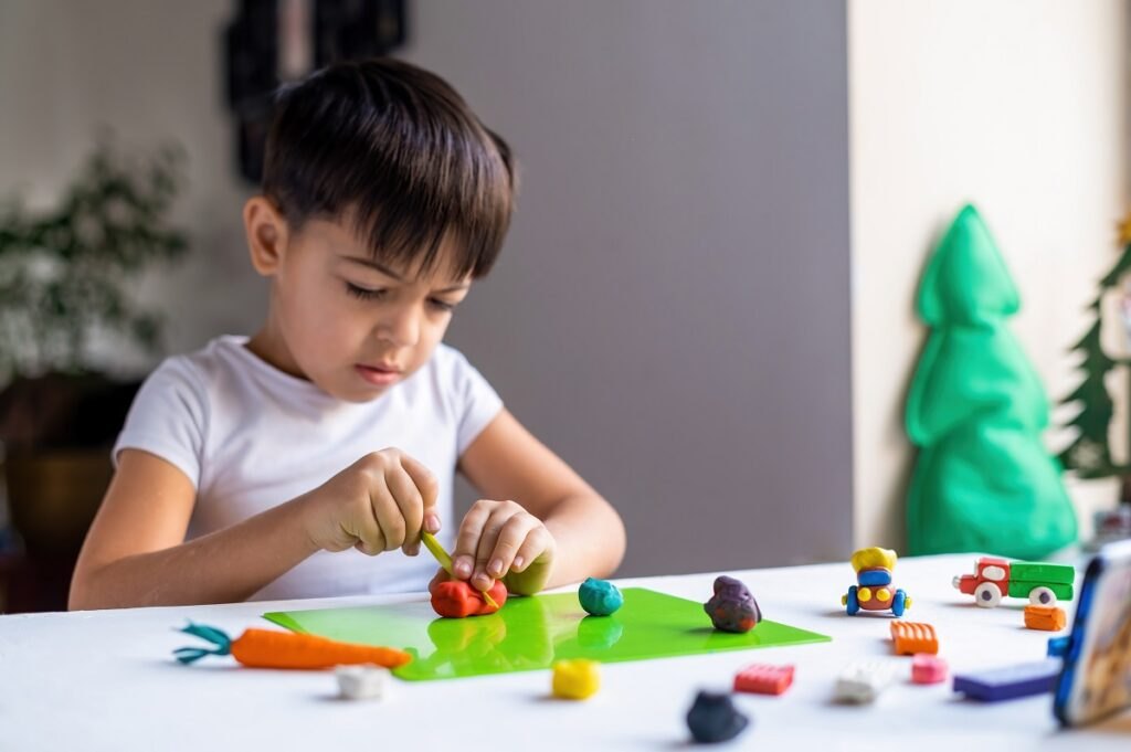 Development of motor skills in children: games that develop hand motor skills Small-caucasian-boy-playing-with-colored-plasticine-making-figures-white-table-happy-child-idea