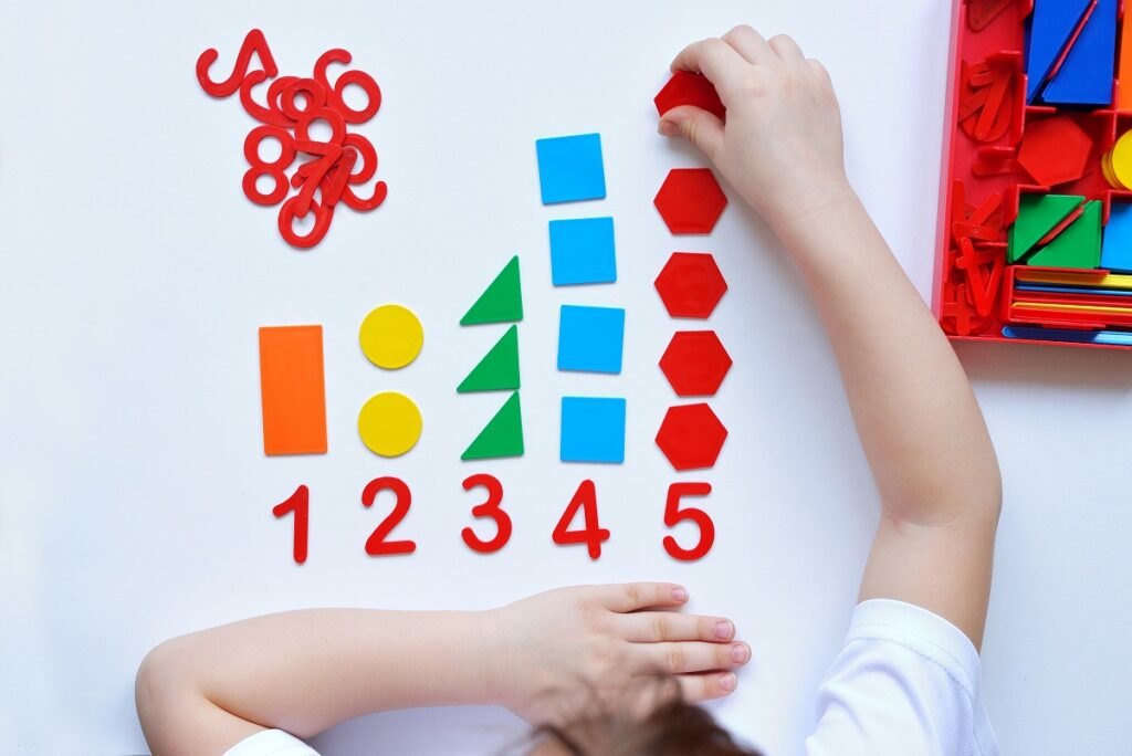 Jak nauczyć dziecko rozpoznawać cyfry i liczyć? Child-learns-number-line-geometric-shapes-preschooler-works-with-montessori-material