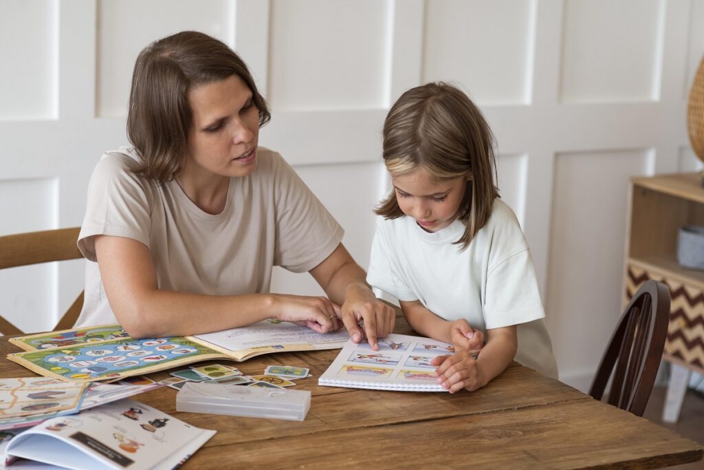 Jak uczyć dziecko języka angielskiego w domu? Woman-helping-girl-study-medium-shot