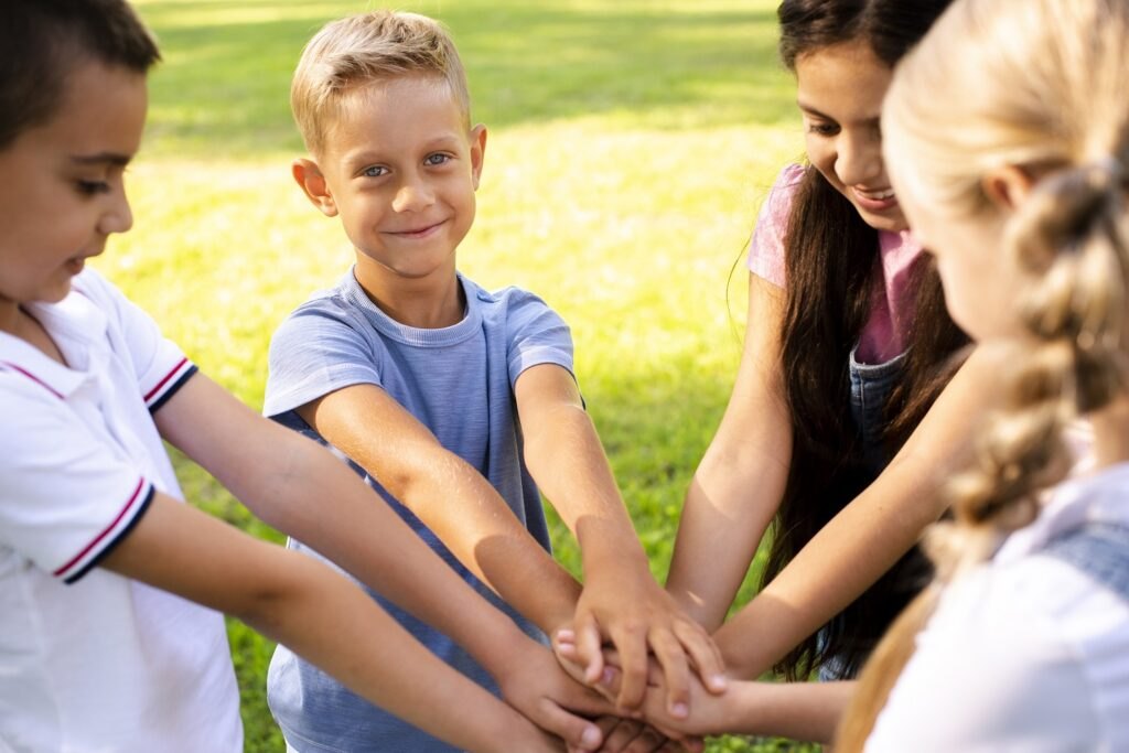 Zalety gier zespołowych na świeżym powietrzu dla dzieci Cheerful-children-joining-hands-together