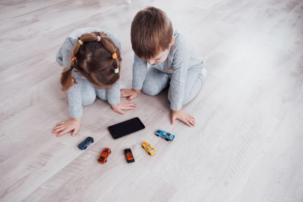 Jak pomóc dziecku w nawiązywaniu kontaktów z rówieśnikami Top-view-children-using-digital-gadgets-home-brother-sister-pajamas-watch-cartoons-play-games-their-technology-tablet